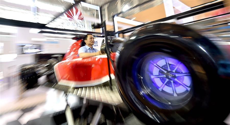 A visitor tries out a driving simulator at Chinese telecom giant Huaweis exhibition during the first World Intelligence Congress in Tianjin