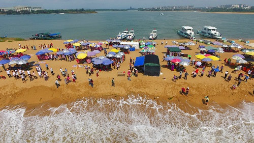 Tourists line the waterfront at the Yudai Beach sceinic area in Boao Hainan Province