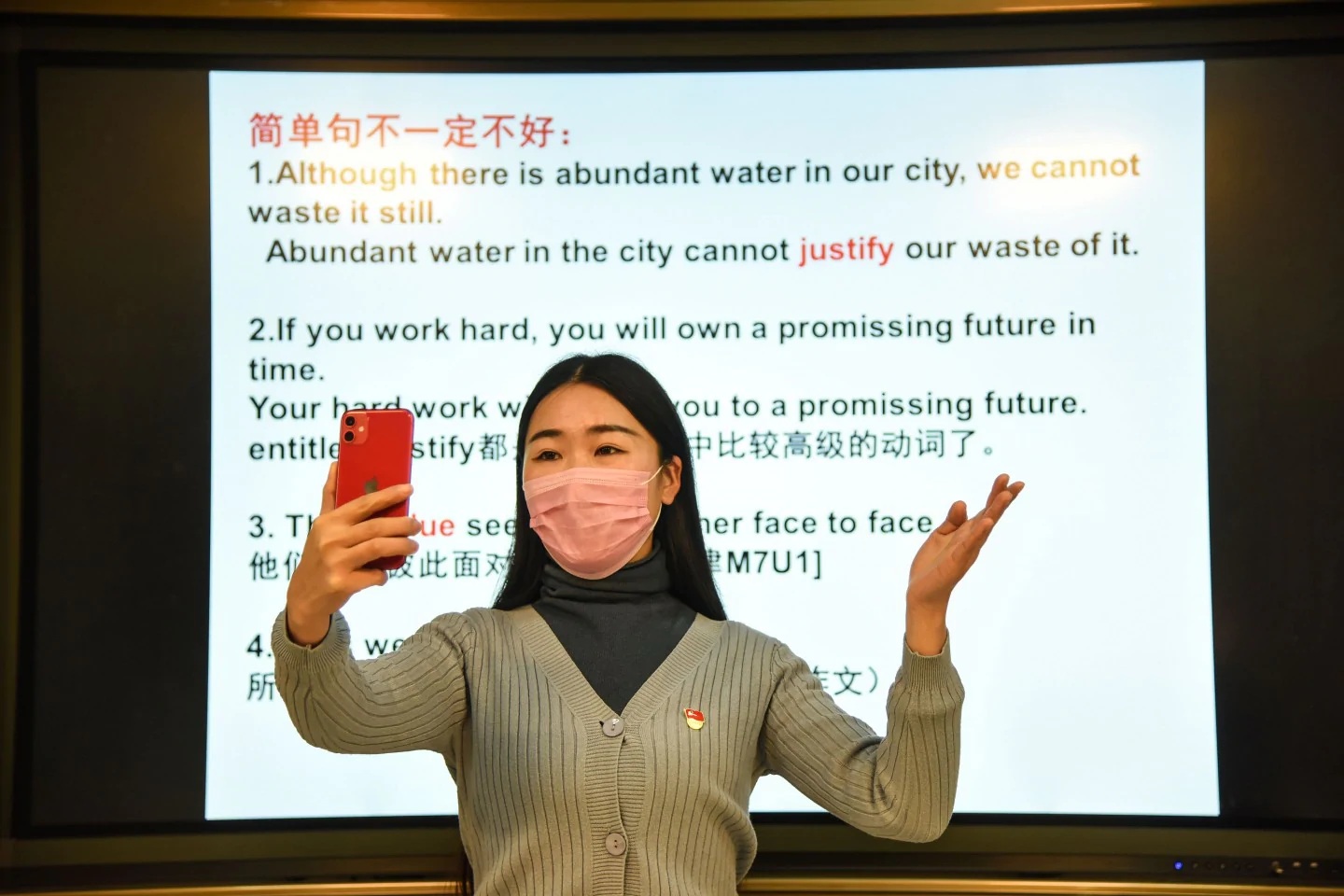 A teacher gives a lecture with her smartphone during an online class at a middle school in Donghai