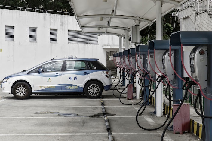A BYD E6 electric taxi is charged at the companys charging station in Shenzhen