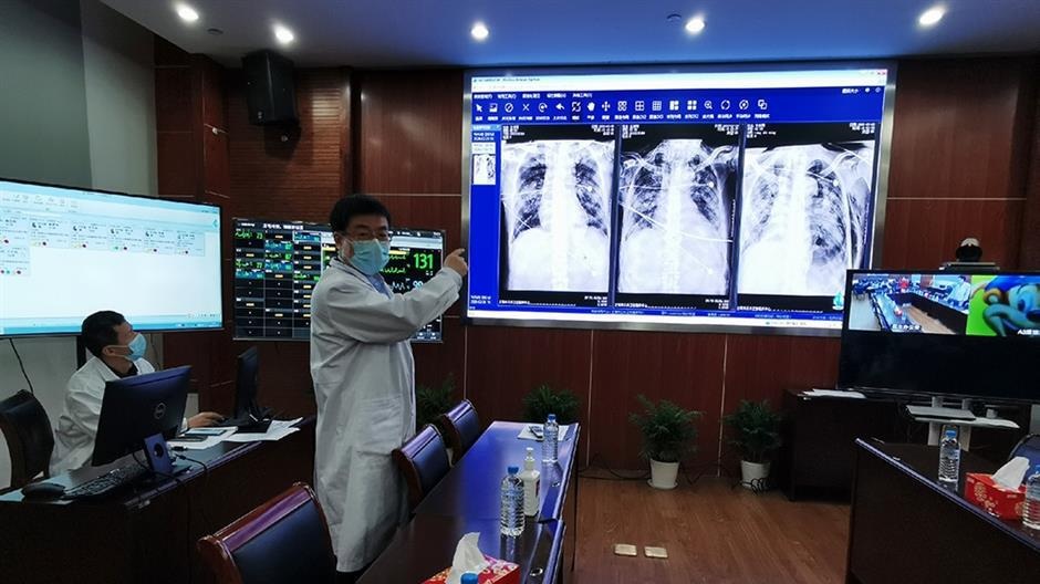 Dr Hu Bijie discusses CT scans with fellow doctors at his headquarters where he can monitor patients data and make remote video rounds at the Shanghai Public Health Clinical Center
