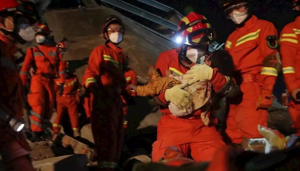 Rescuers carried a young boy from the rubble
