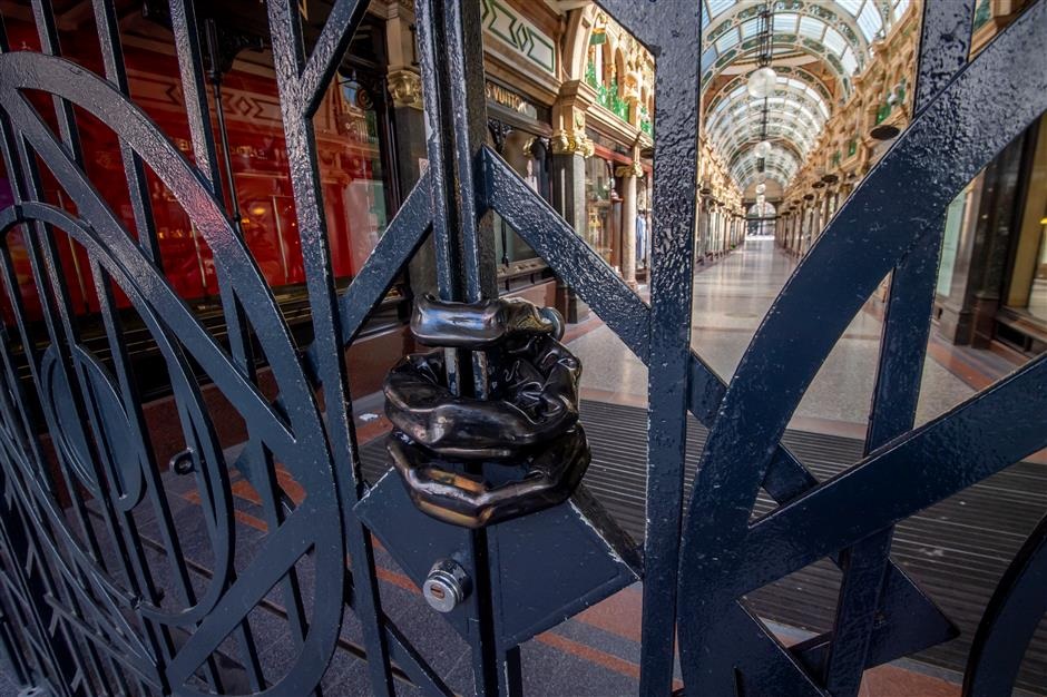 A chain is seen on the gates of a closed shopping arcade in Leeds city center West Yorkshire on April 14 2020
