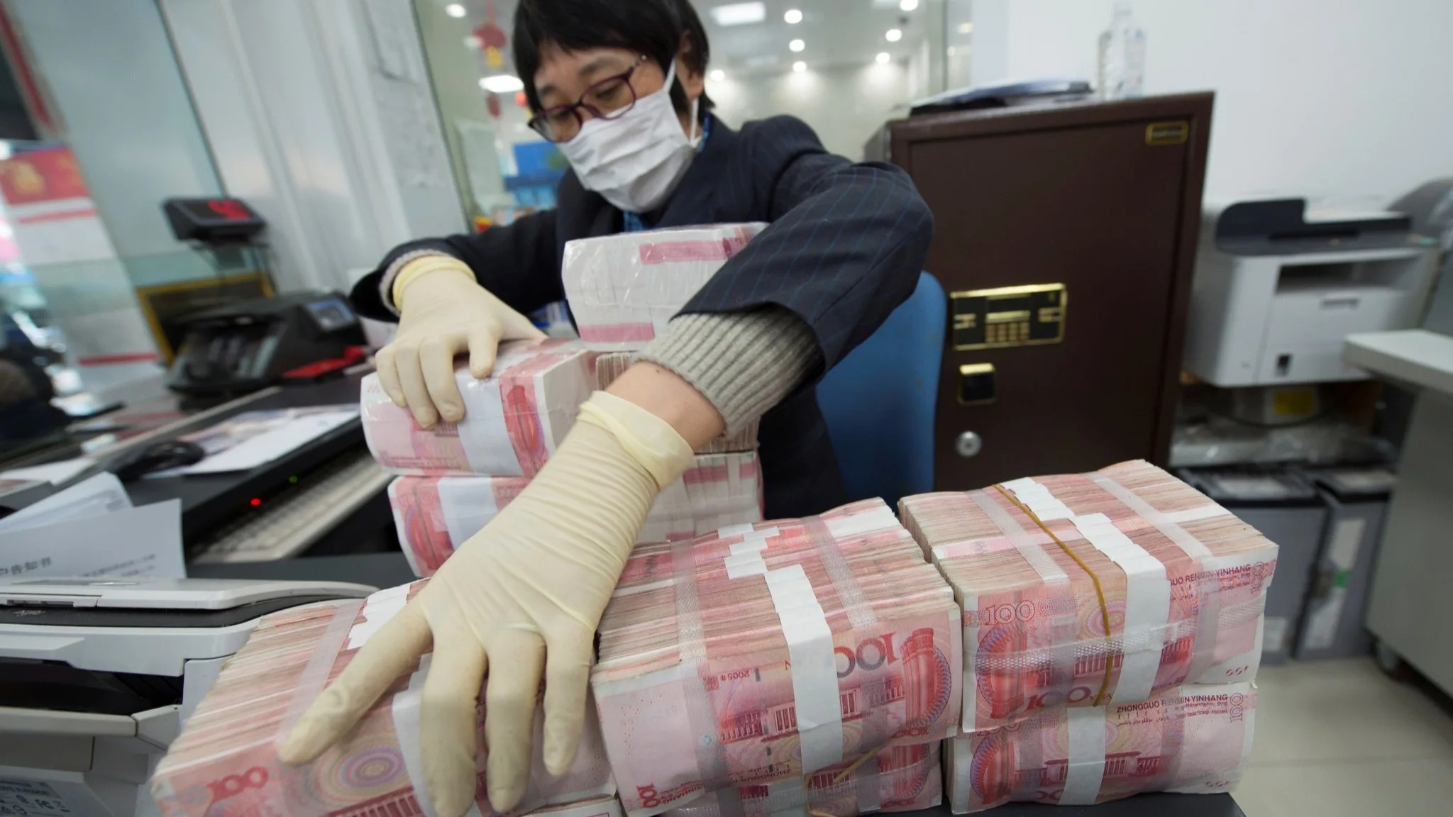 A bank employee stacks yuan banknotes