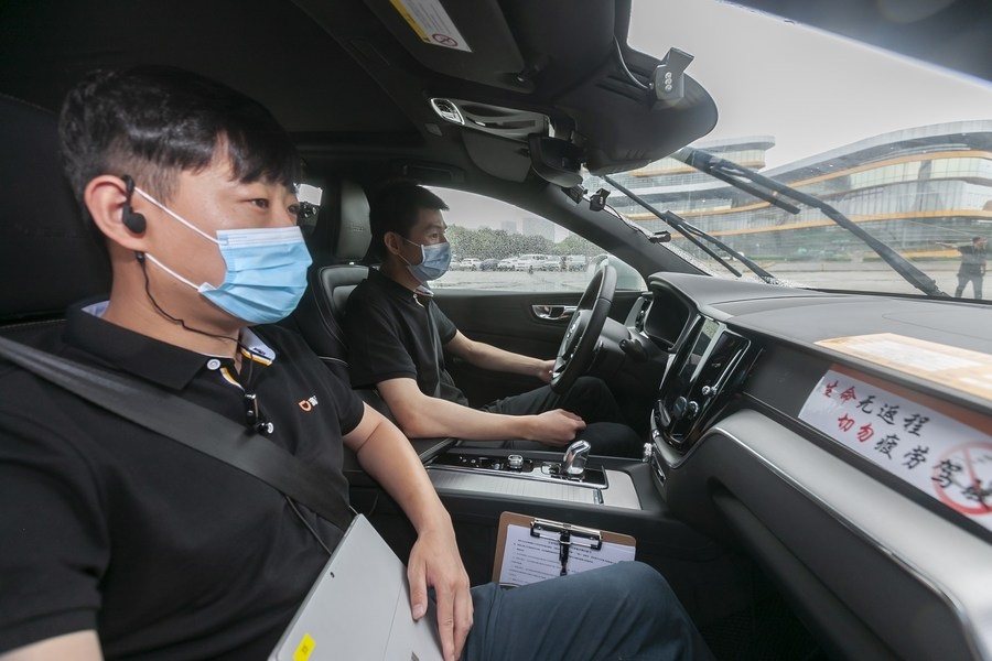 A tester front holds a device to record data in an autonomous vehicle in Shanghai
