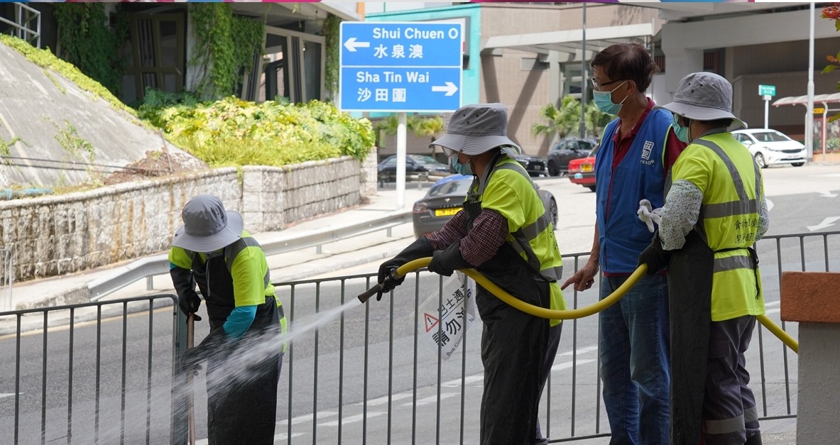 Cleaners spray disinfectant fluid to clean the street at Sha Tin Hong Kong on Saturday