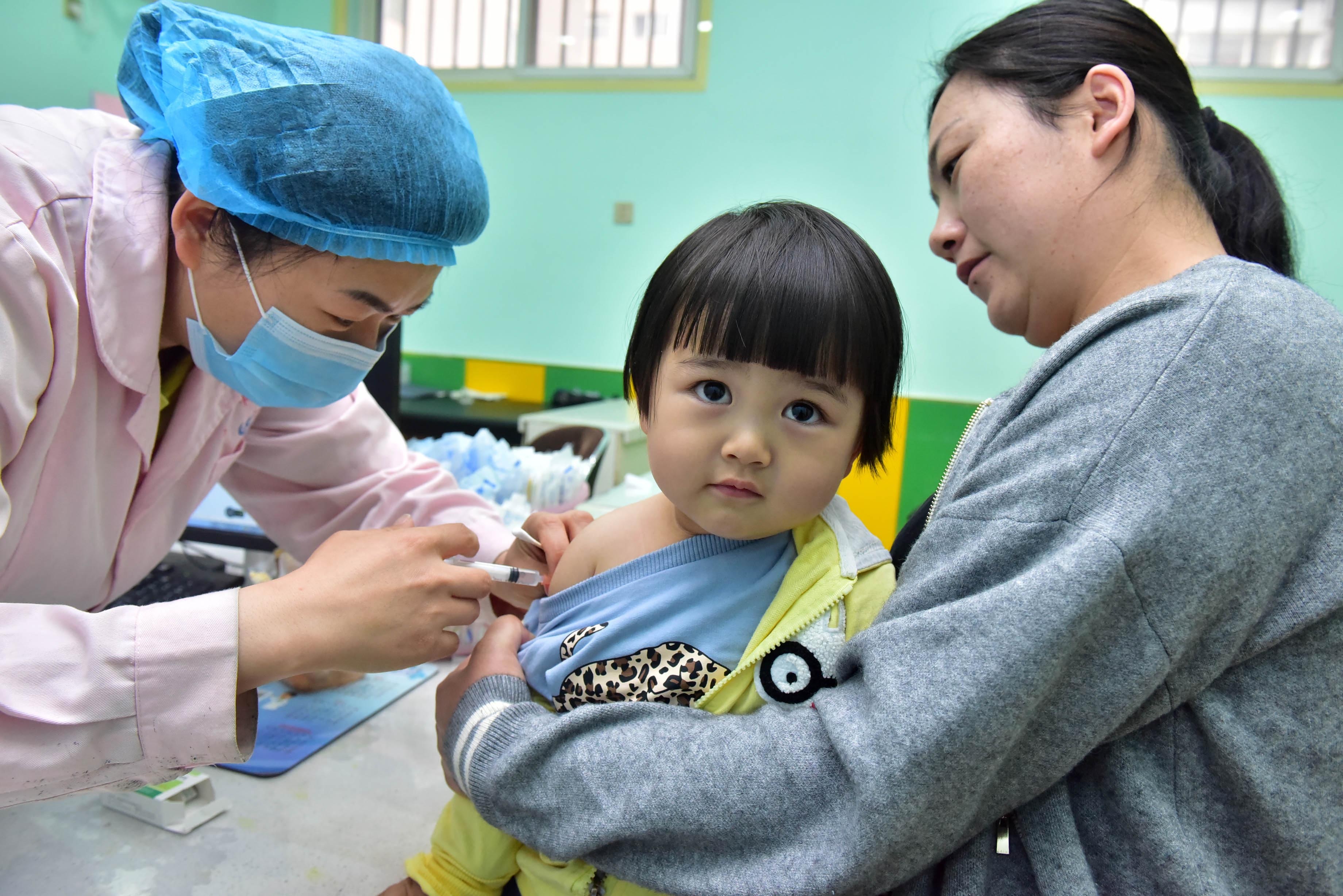 A child receives a vaccine at a disease prevention and control center