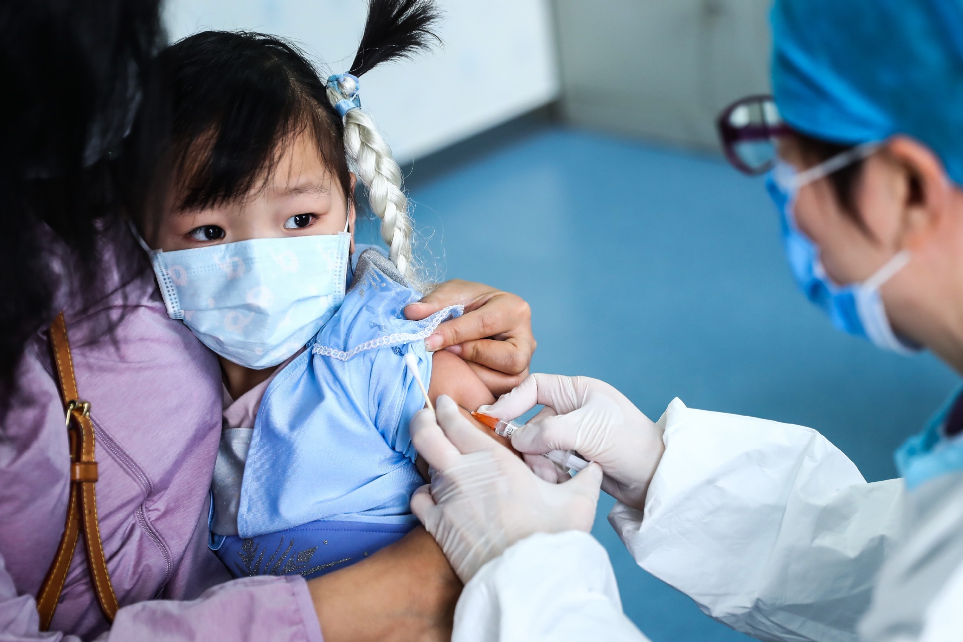 A child receives a vaccine shot at a health center