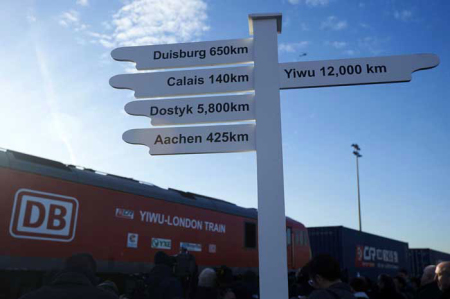 A sign shows the distance from Londons Eurohub rail freight depot to some destinations as a freight train sets off with containers laden with goods from China