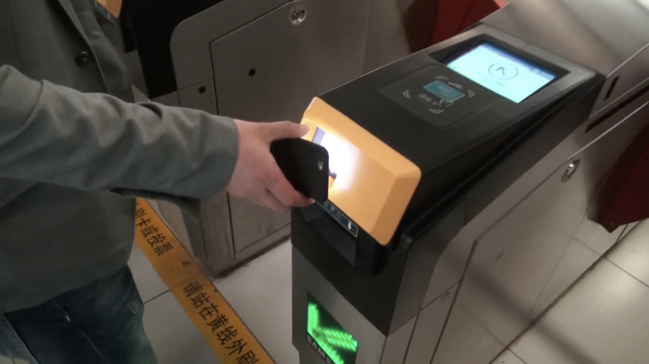 A passenger getting through subway gate by scanning a QR code