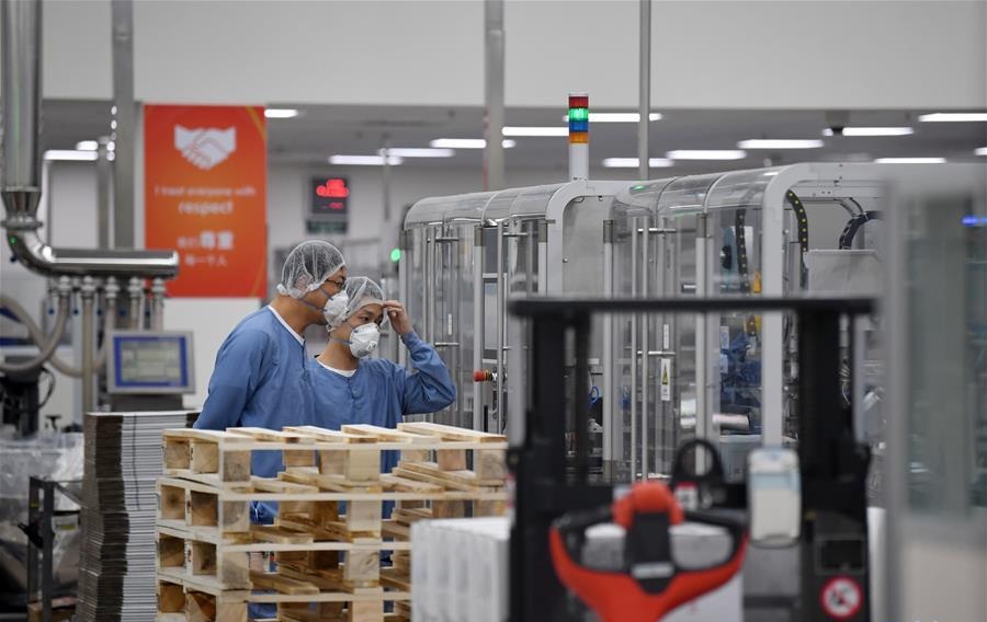 Workers inspect the performance of equipment at the workshop of Novo Nordisk China Pharmaceutical Co. Ltd. in Tianjin