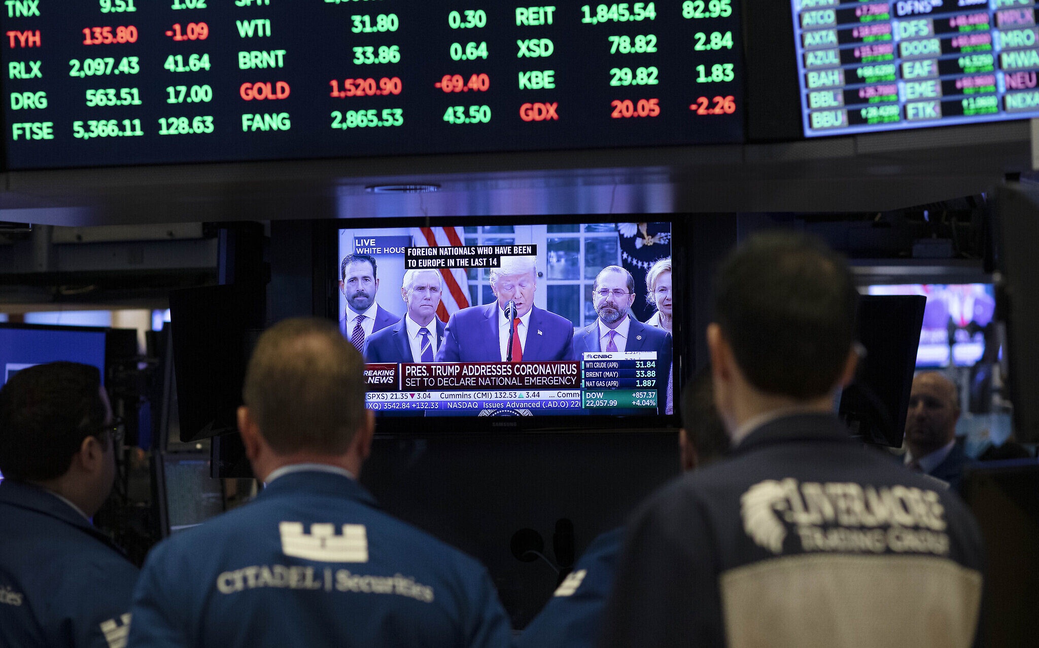 Traders listen at the New York Stock Exchange to US President Donald Trumps televised speech from the White House