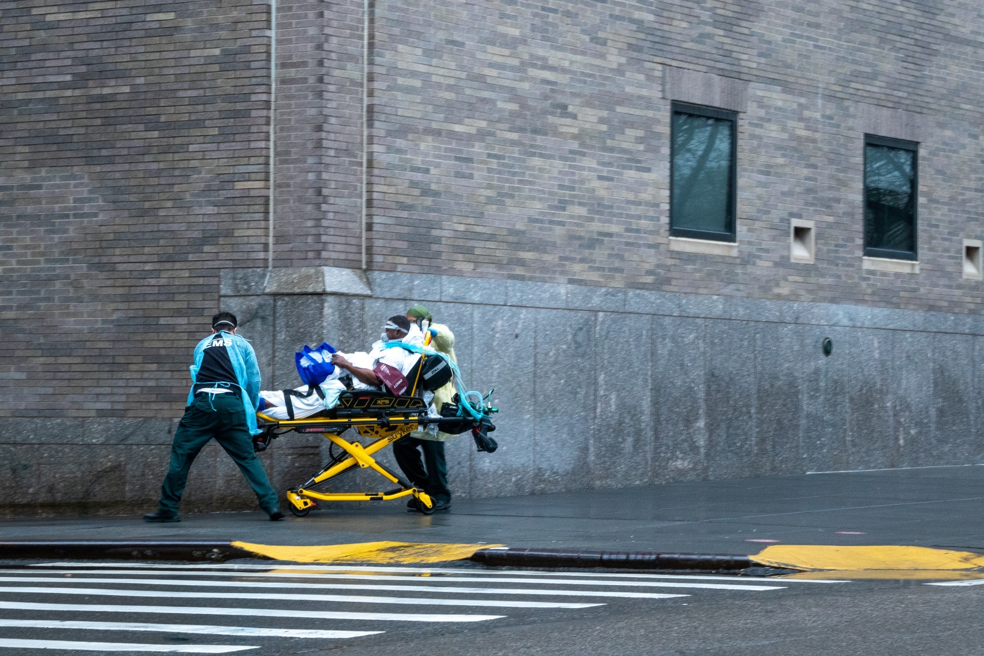 Medical staff transport a patient on the side walk outside of Mount Sinai hospital in New York on April 13