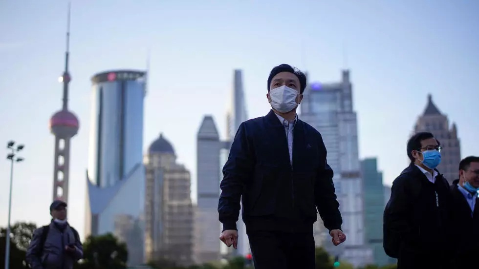 People wear protective face masks following an outbreak of the novel coronavirus disease COVID 19 at Lujiazui financial district in Shanghai China March 19 2020
