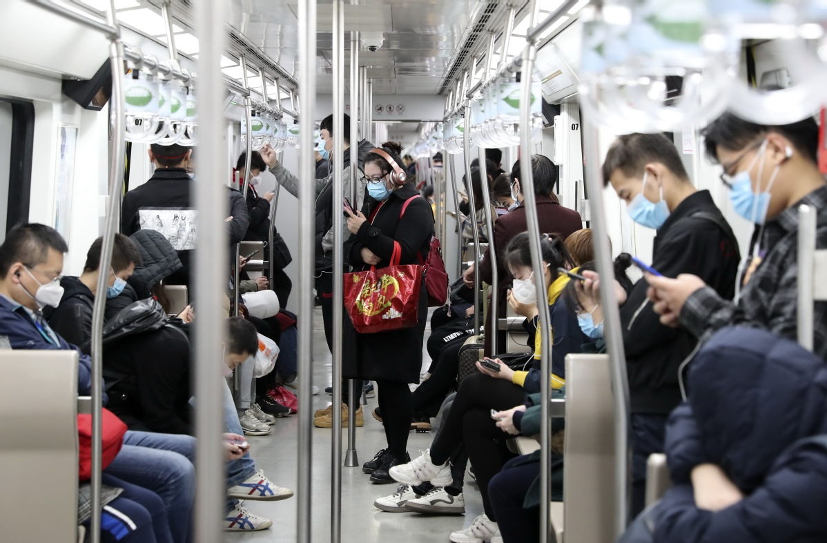 Passengers use mobile apps in a subway train in Beijing